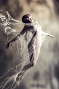 Dancer with flowing fabric against a blurred background