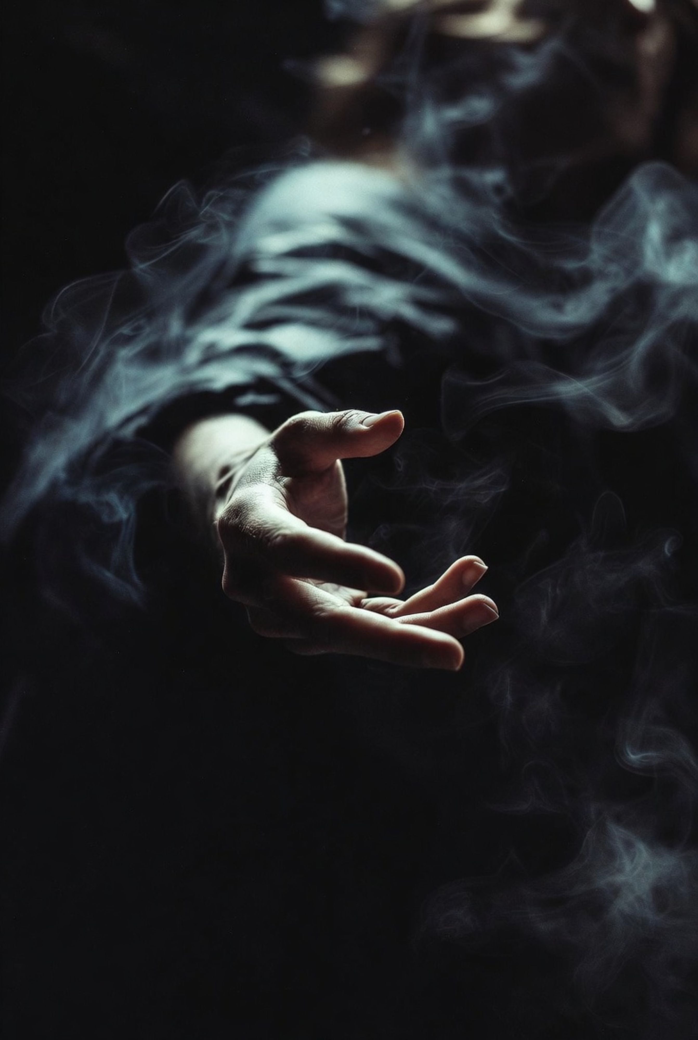 Hand with a small object surrounded by dark smoke