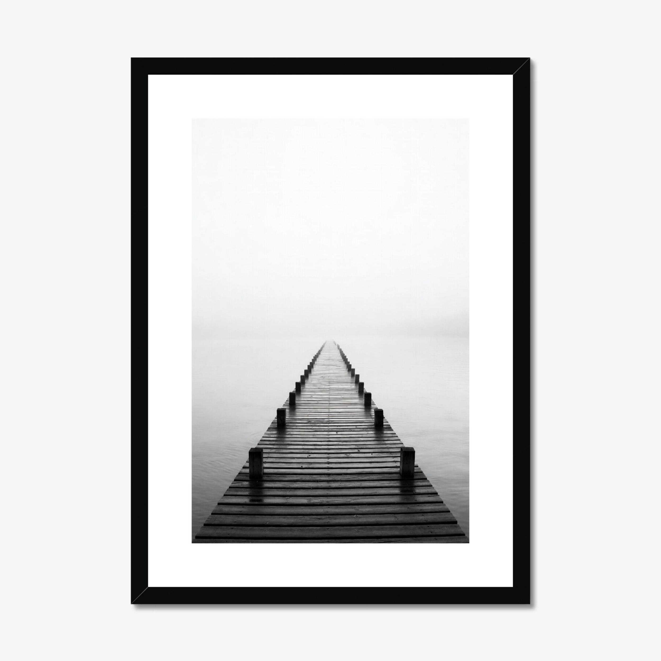 Framed black and white photograph of a dock extending into the water on a foggy day.